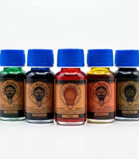 Cinco pequeñas botellas de vidrio con tapa azul, conteniendo laca para bombillas de colores verde, azul, rojo, amarillo y ámbar.