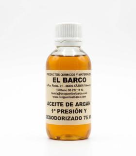 Frasco pequeño de vidrio transparente con tapa blanca, contiene aceite de argán dorado, etiquetado en color crema.